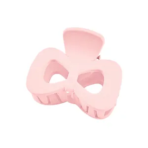 Close-up of pink bow hair claw clip with matte finish and secure spring mechanism