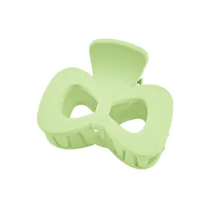 Detail of mint green matte butterfly hair claw clip with a hollowed-out wing design
