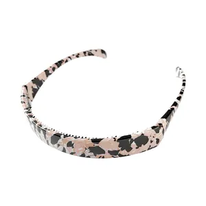 Macro view of non-slip comb teeth on foldable pink marble resin headband for secure grip