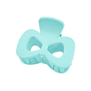 Detail of light blue matte bow hair claw clip with hollowed-out cloud design for women