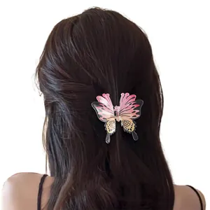 Pink and orange gradient butterfly hair claw clip worn on a woman's hair for stylish updo