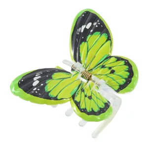 Gros plan sur la pince à cheveux papillon verte avec motifs noirs et ressort en métal