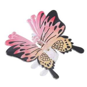 Detailed close-up of a pink gradient butterfly hair claw clip with realistic black patterns