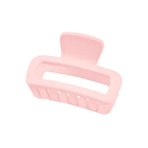 Close-up of matte light pink rectangular hair claw clip with a modern hollow design