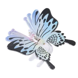 Close-up of a gradient butterfly hair claw clip with black dots and metal spring