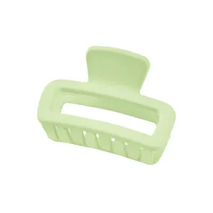 Detail view of light green matte square hair claw clip with hollow design and teeth