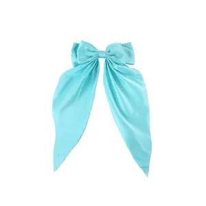 Close-up of light blue large satin bow hair clip with elegant long flowing ribbons