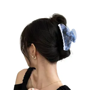 Blue marble patterned crescent hair claw clip for women shown on model hair