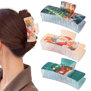 Detail of Christmas themed large rectangular hair claws with festive holiday patterns