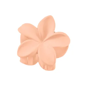 Close-up of matte light orange frangipani hair claw clip showing spring mechanism