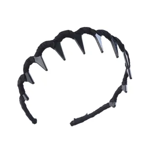 Détail du serre-tête en tissu noir orné de pointes triangulaires en plastique style punk