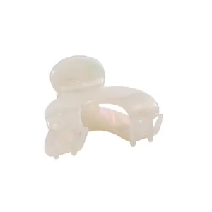 Macro detail of cream white acetate hair claw clip with pearlescent iridescent finish
