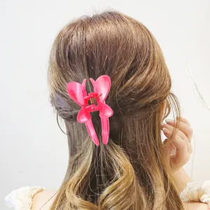 Pink butterfly hair claw clip with cutout design shown on a woman back hairstyle