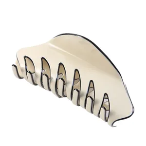 Elegant cream yellow hair claw clip with black trim on a clean white background