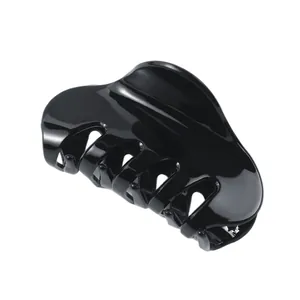Glossy black acetate hair claw clip with minimalist curved design on white background