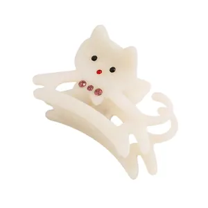 Detail of cream acetate cat hair claw clip featuring pink rhinestones and cute cat shape