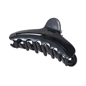 Detail of glossy black acetate crescent hair claw with gold Barrette La France lettering