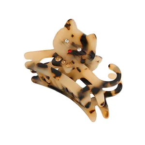 Detailed close-up of a tortoiseshell cat hair claw clip with colorful sparkling rhinestones
