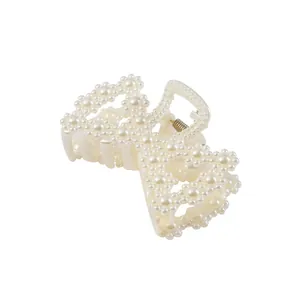 Eleganter Perlen-Haarclip mit cremefarbenen Blütenblättern und goldener Feder