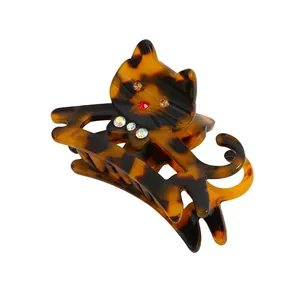 Cartoon tortoiseshell cat hair claw clip with colorful rhinestones on white background