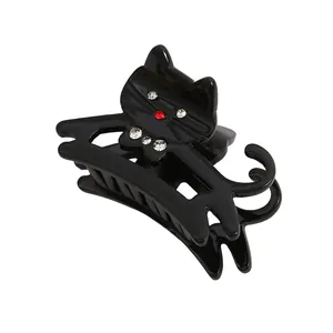 Close-up of black cat hair claw clip with sparkling rhinestones and glossy finish