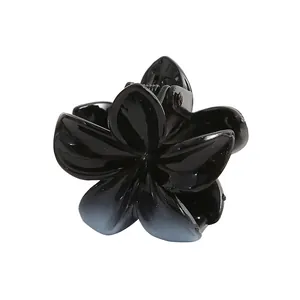 Detail view of a 4cm black gradient flower hair claw clip with glossy resin petals