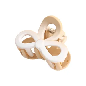 Close-up of the smooth cream and white resin flower hair claw clip with silver spring
