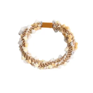 Détail macro de l'élastique à cheveux avec pompons en peluche colorés et boucle jaune