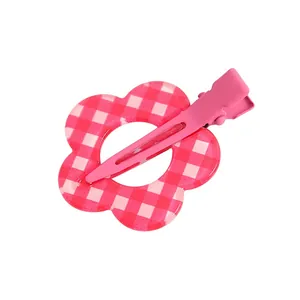 Detalle de pinza para el pelo floral con cuadros rojos y clip metálico rosa pastel