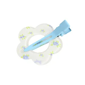 Detalle de pinza para el pelo de metal azul cielo con flor de resina floral