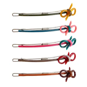 Set of 5 colorful acetate bow hair clips with metal snap design on white background