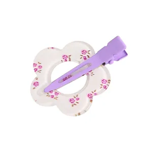 Detalle de la pinza para el pelo de acrílico con estampado de rosas y clip de metal