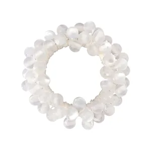Detail of beaded elastic hair tie featuring opalescent cat eye stones and pearly beads
