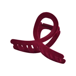 Detailed close-up of a large velvet hair claw clip in deep burgundy with cross design