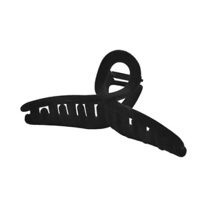 Macro detail of black flocked hair claw clip with strong metal spring and matte texture