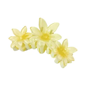 Close-up of translucent cream yellow flower claw clip with jelly texture on white back