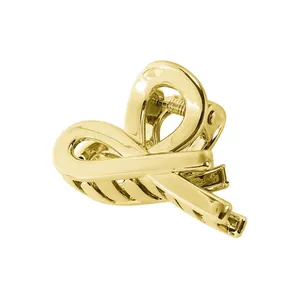 Detailed view of hollow geometric golden metal hair claw clip with glossy finish