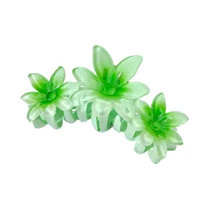 Close-up of green gradient plumeria flower hair claw clip with translucent resin petals