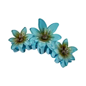 Detailed view of sky blue floral hair claw clip featuring three translucent petals and resin teeth