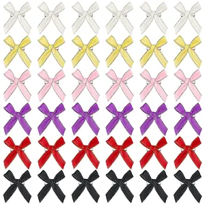 Vue détaillée de 36 nœuds en ruban satin coloré avec bord argenté et pinces à cheveux