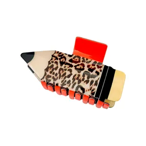 Detail van creatieve haarclip in potloodvorm met luipaardprint en glanzende oranje tanden