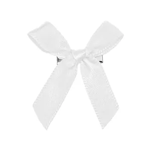 Détail d'un nœud en satin blanc avec pince crocodile en métal argenté et texture lisse