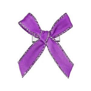 Vue détaillée d'une pince à cheveux nœud en satin violet avec paillettes argentées et base