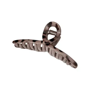 Detailed view of light grey and black tortoiseshell claw clip with secure metal spring