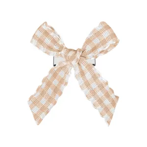Détail d'une barrette noeud à carreaux beige et blanc avec base en métal poli brillant