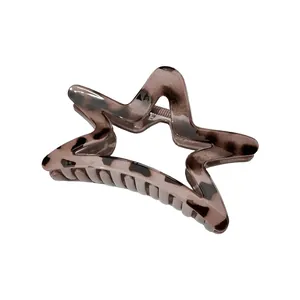 Detail of star-shaped hair claw clip with tortoise leopard pattern and metal spring
