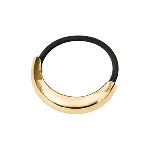 Detail eines polierten goldenen Metallelements auf einem schwarzen elastischen Haargummi