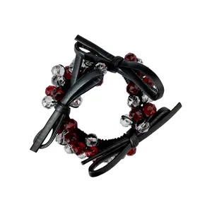 Detail of black leather bow hair tie with red faceted beads and elastic band