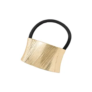 Detalle de la banda elástica negra para el pelo con adorno de metal dorado cepillado