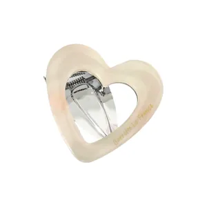 Detail of cream pearlescent heart hair clip featuring gold Barrette La France text